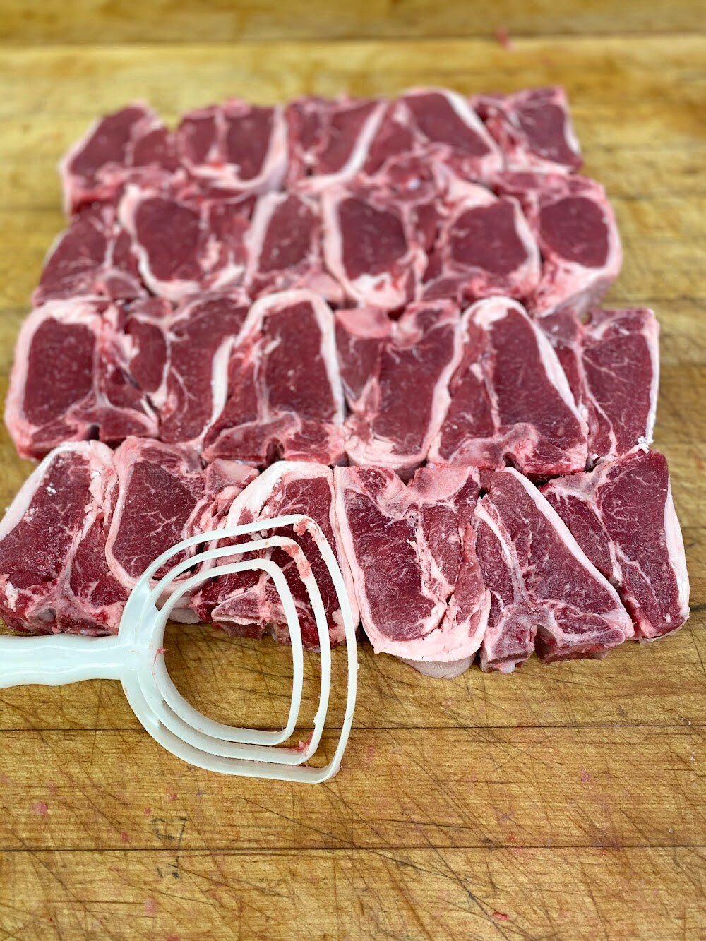A marbled bone-in ribeye on the butcher block
