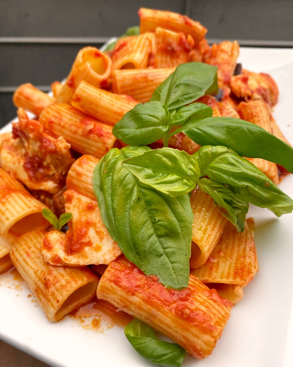 A tray of baked rigatoni with basil, fresh from our kitchen
