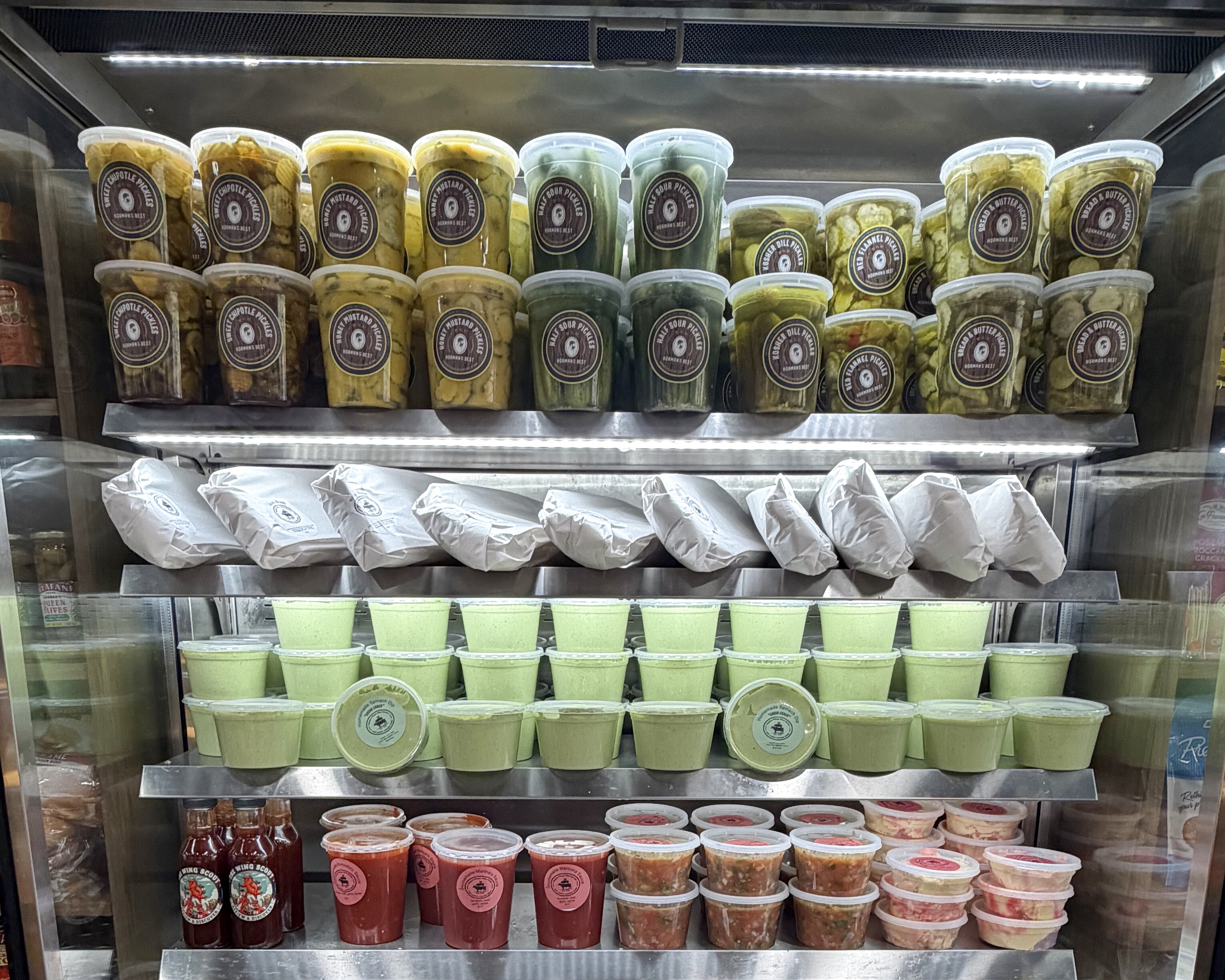 Our refrigerated deli case stocked with house-made dips, salads and prepared sides in Babylon Village Meat Market containers