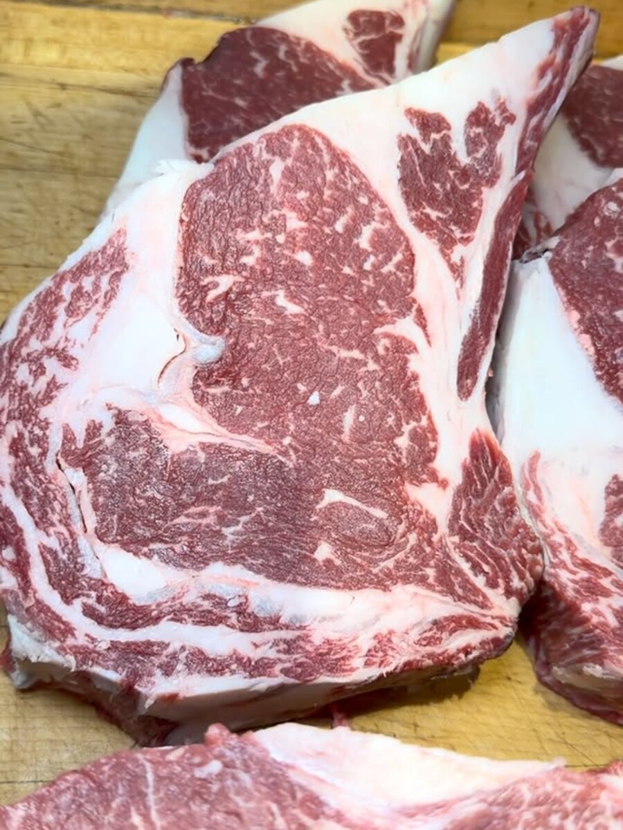 Bone-in ribeye steaks, fresh cut on the board