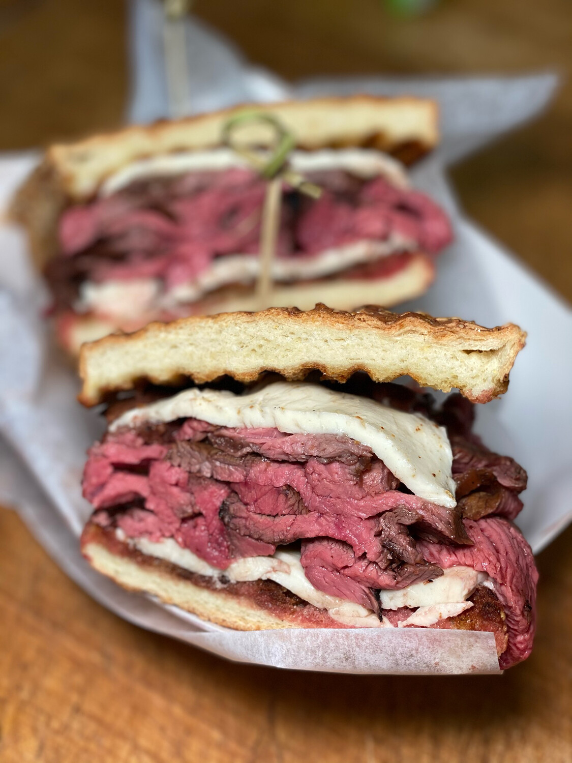 A towering pastrami sandwich, cut to show the stack